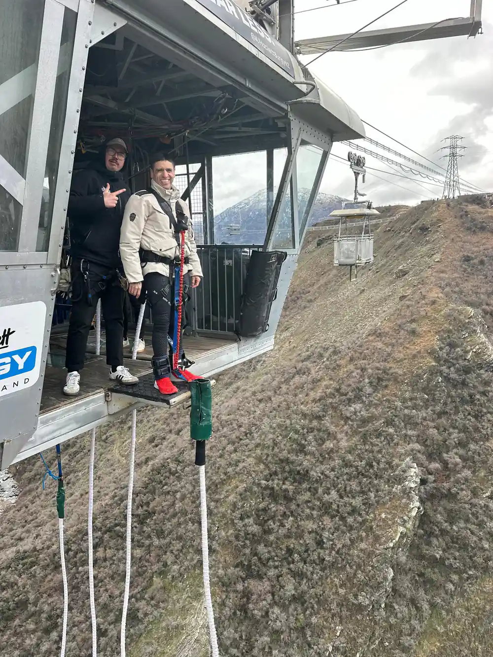 Crew and a jumper on a platform inside a cableway pod