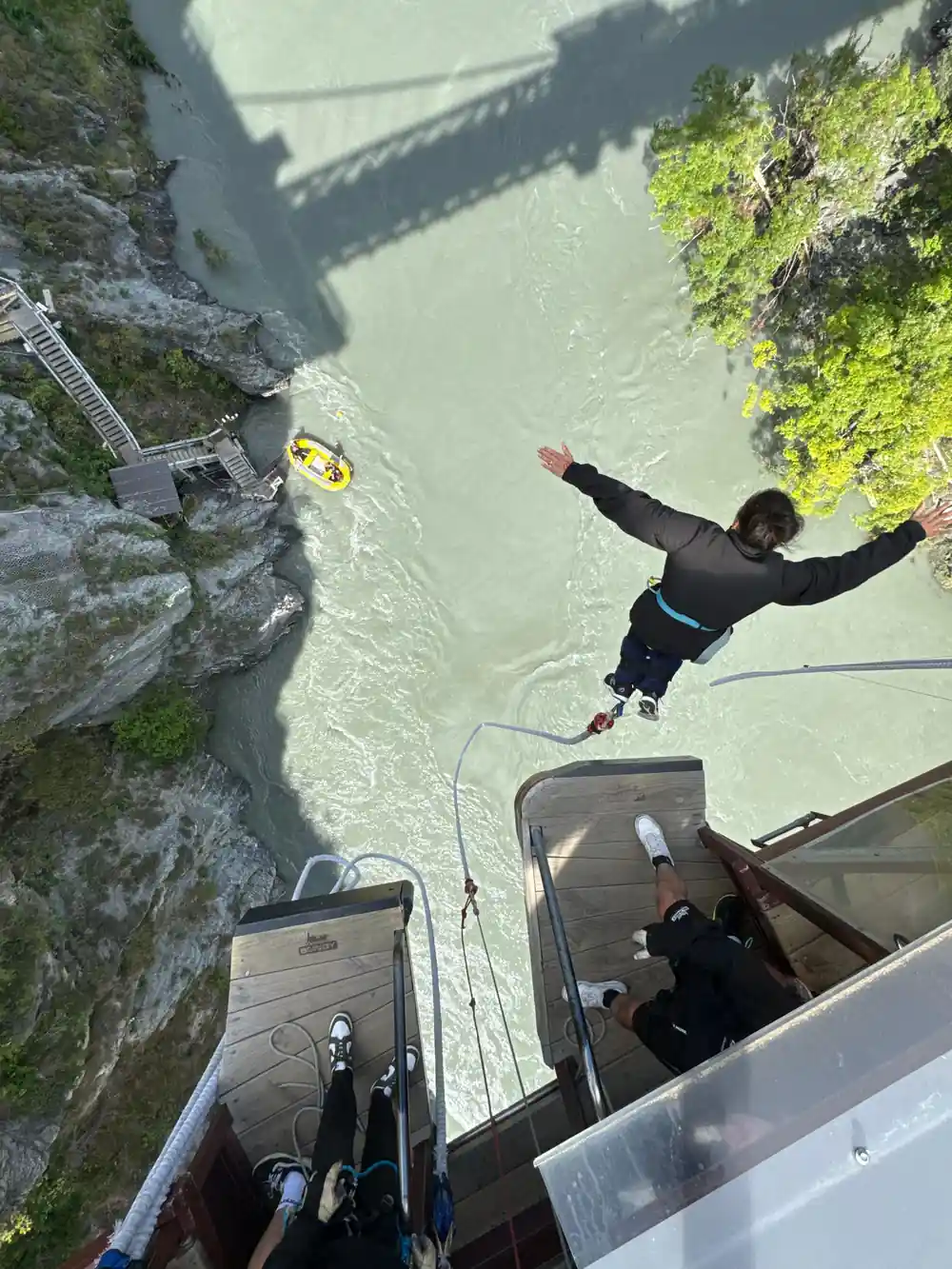 A jumper falling with arms wide, the boat small on the water below