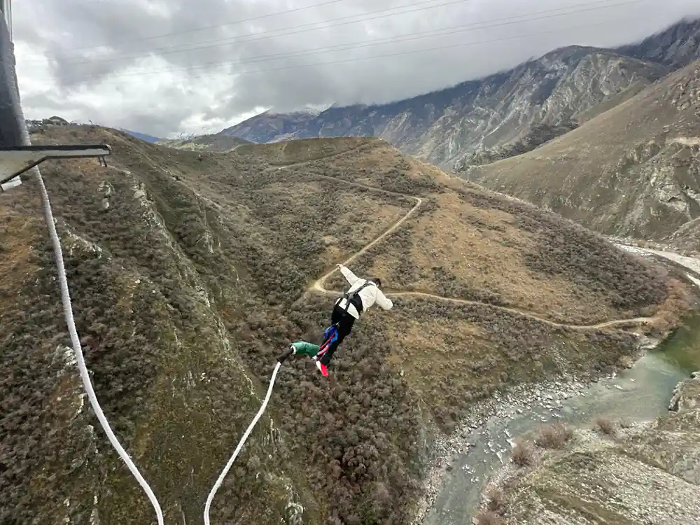 A jumper falling into a dry brown canyon at the operator other site