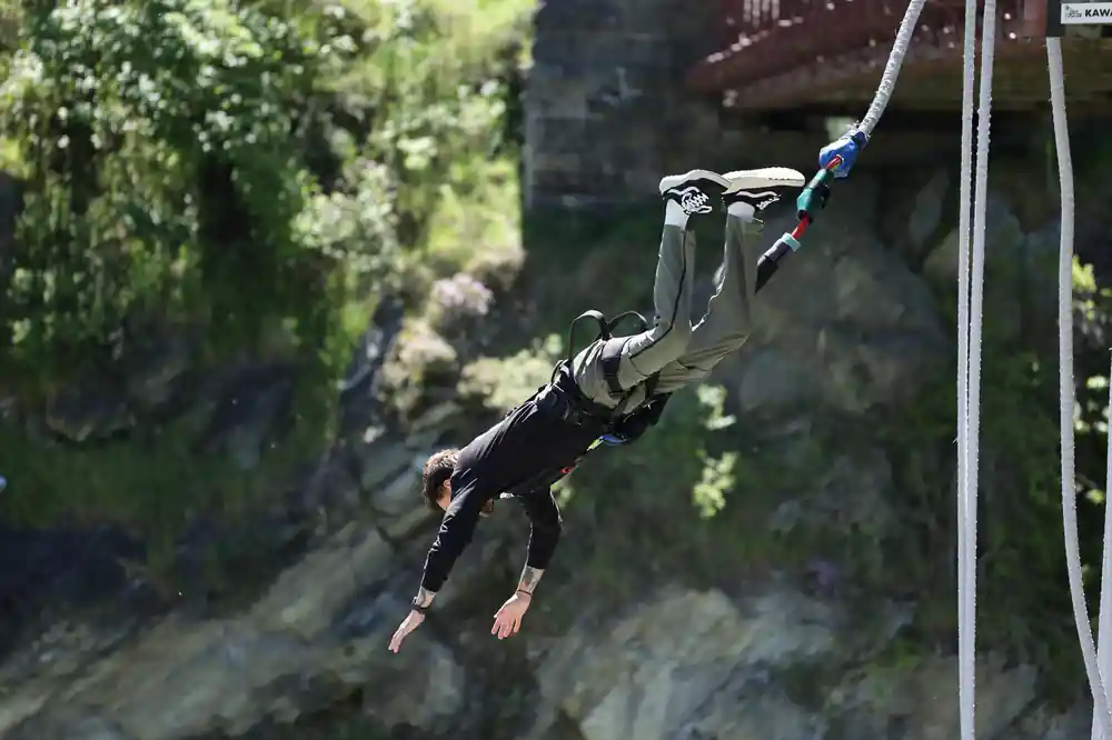 A jumper falling head first with the cord trailing above