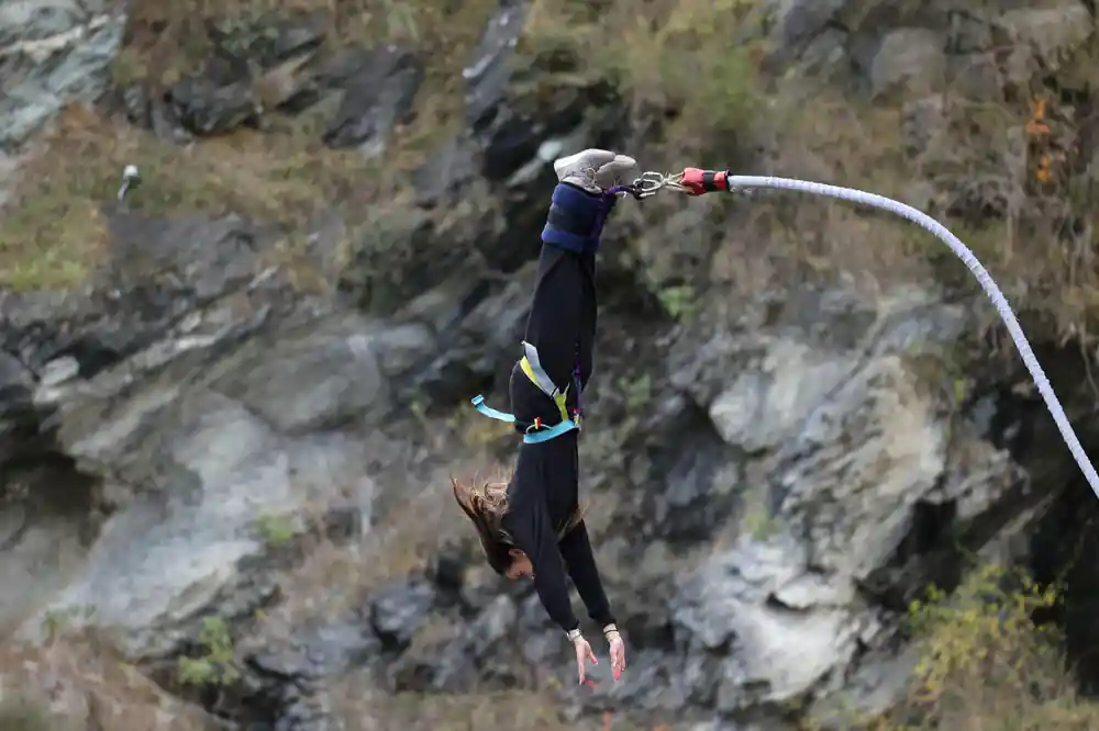 A jumper falling past the rock wall with hair streaming