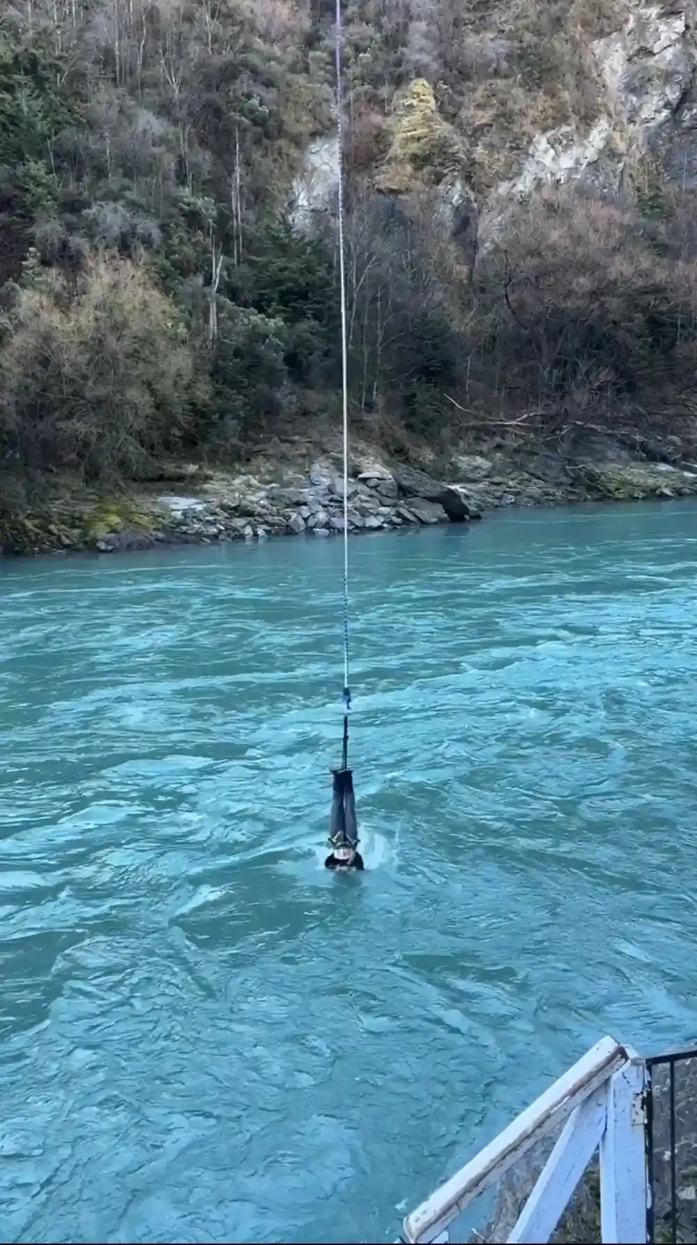 A jumper hanging low above fast green water waiting for the boat