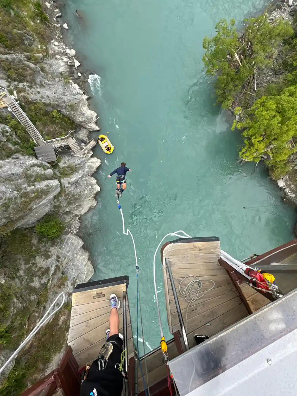 A jumper low over the river with the boat coming out to collect them
