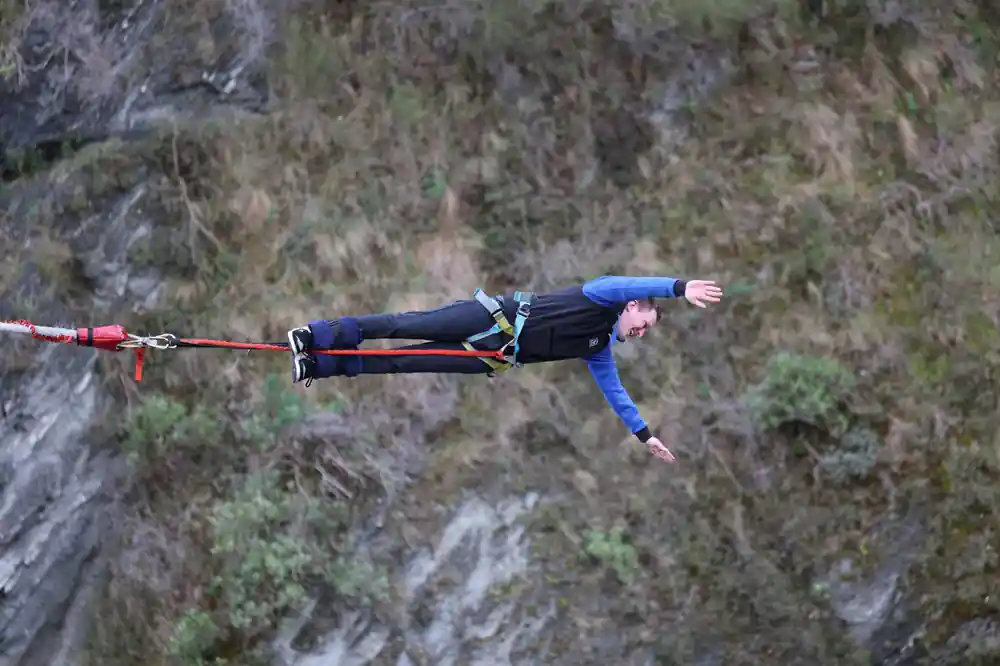 A jumper stretched flat in the air against the canyon side