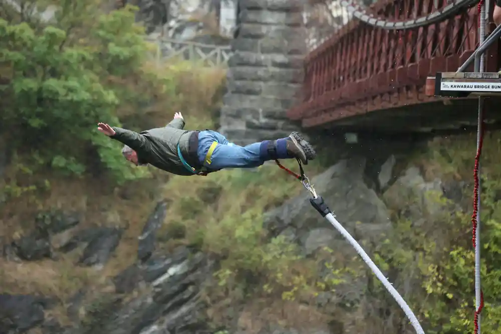 A jumper stretched out in a dive beside the stone bridge pier